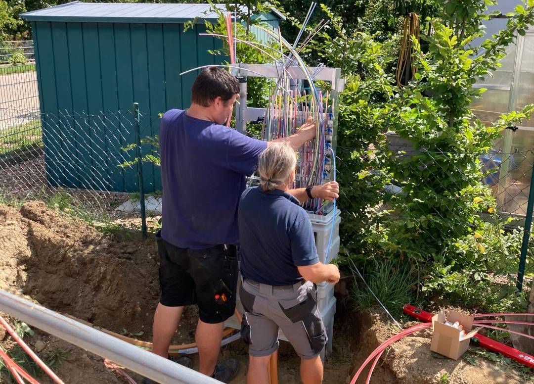 Glasfaserausbau Bayern: Techniker installieren NVt-Glasfaserverteiler in Lautenbach mit Kabelmanagement