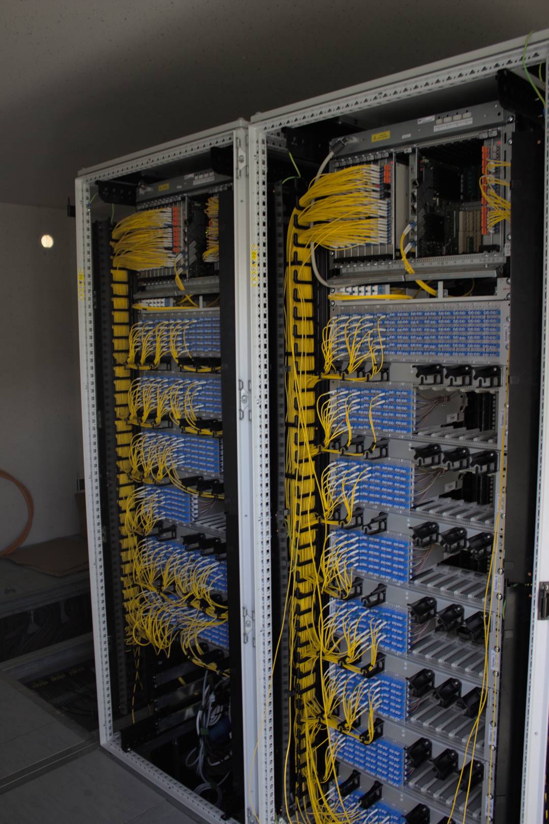 glasfaserausbau-bayern-verteilerbau-aresing-04 Glasfaserausbau Bayern: Innenansicht Glasfaser-Verteilerschrank in Aresing mit Patchpanels und gelben Glasfaserkabeln