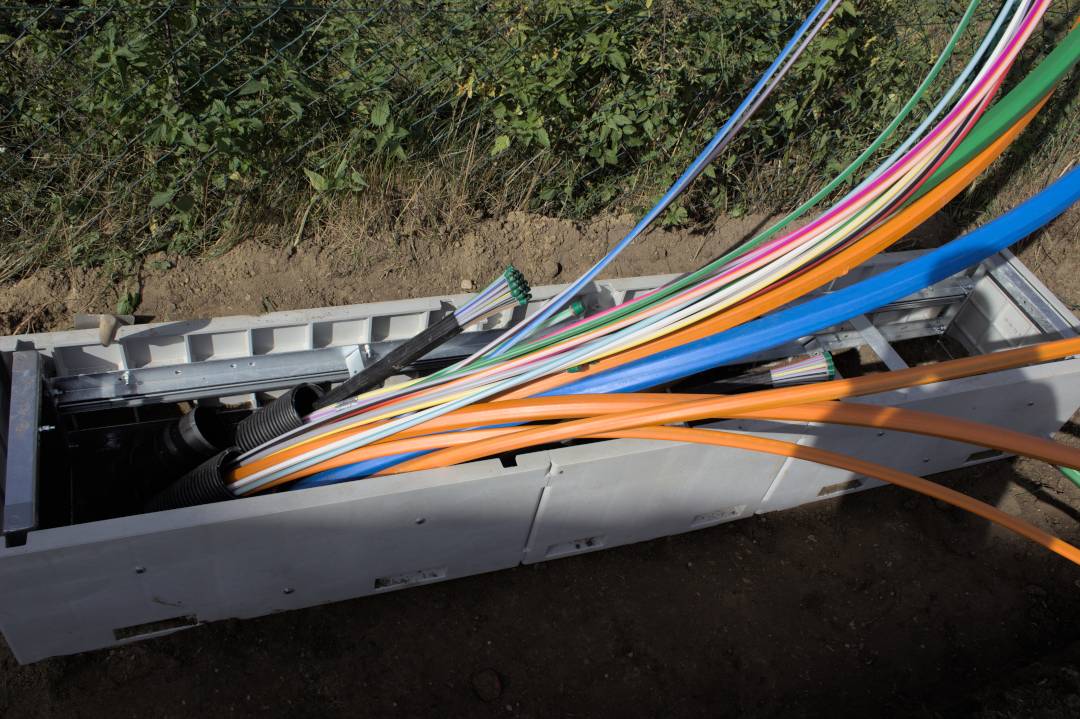 glasfaserausbau-bayern-verteilerbau-autenzell-02 Glasfaserausbau Bayern: Glasfaserkabel-Verlegung in Kabelkanal mit farbcodierten Leerrohren in Autenzell